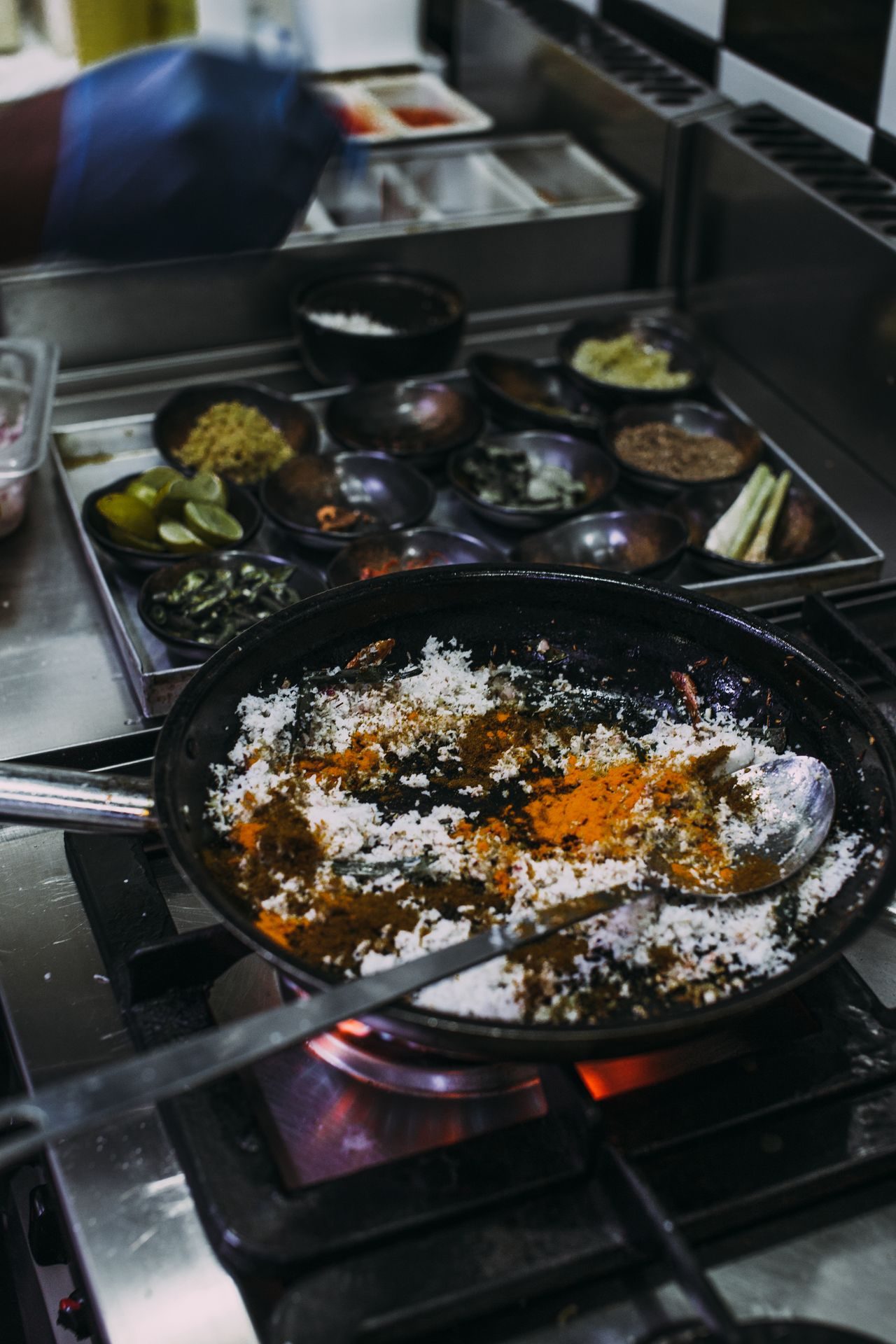 A frying pan with ingredients and herbs in a kitchen