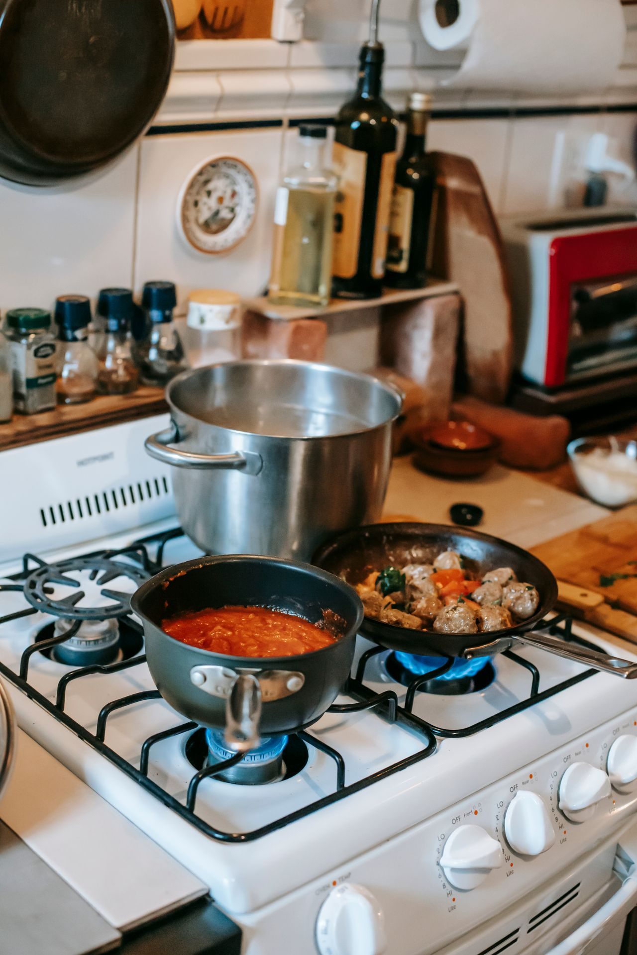 Several pans cooking on a kitchen stove