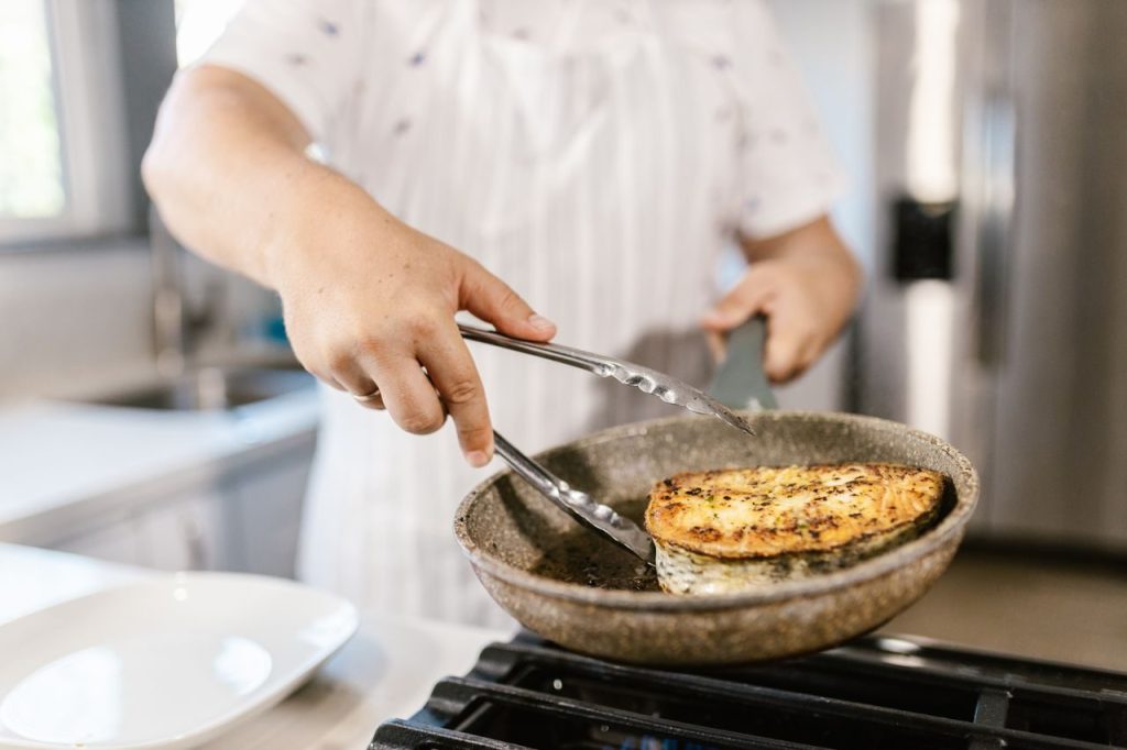 Food being cooked in a frying pan in a kitchen
